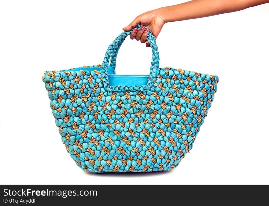 A woman's hand holding a big summer beach bag. A woman's hand holding a big summer beach bag