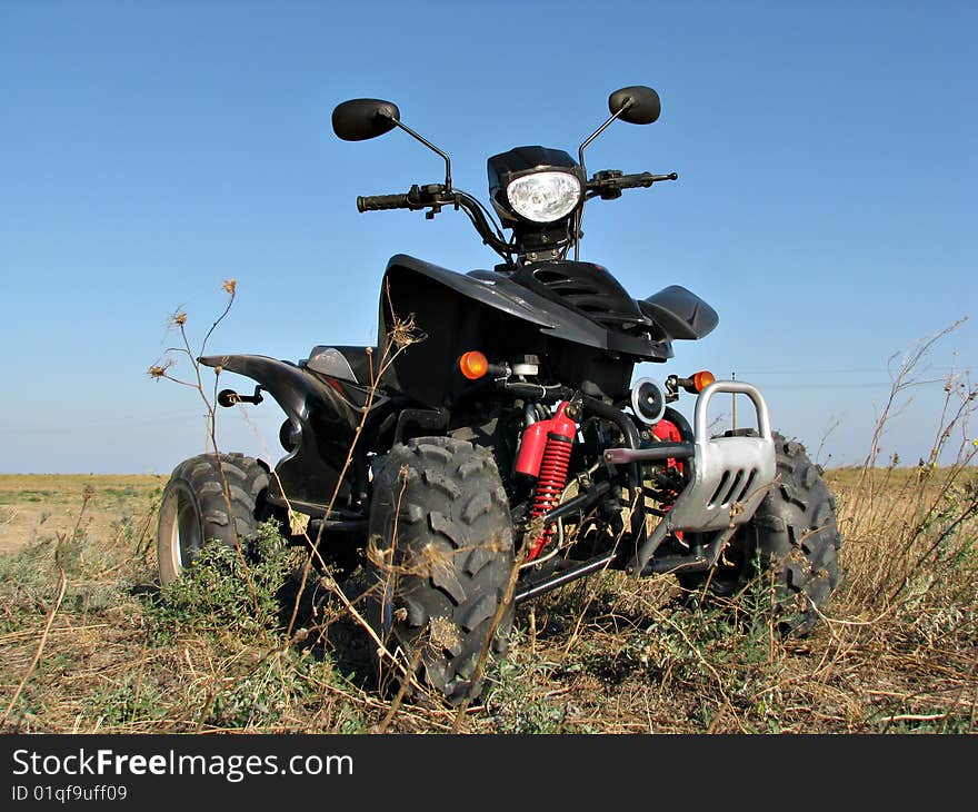 Quad standing in the dry steppe grass. Quad standing in the dry steppe grass