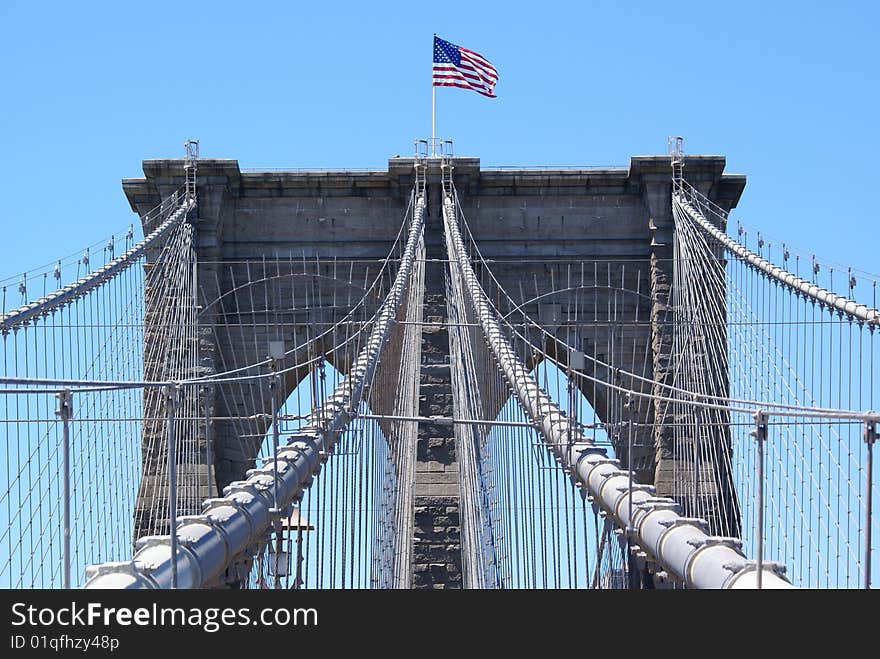 American flag waving over the Brooklyn Bridge