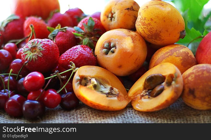 Strawberries, cherries and loquats on green background. Strawberries, cherries and loquats on green background.