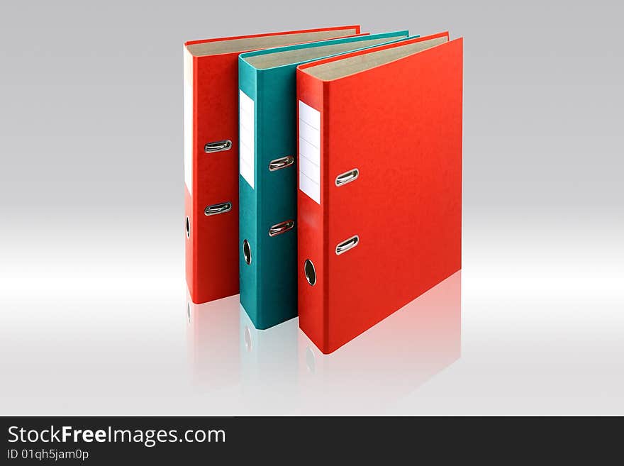 Two red business folders and one green on gray background.