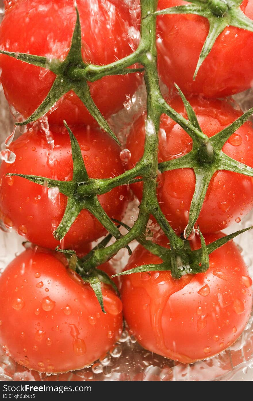 Tomatoes are under water in a kitchen, background