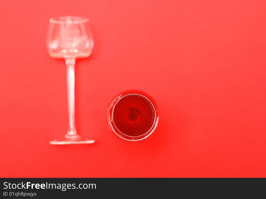 Two glasses, one is full of red wine, second is empty and overturn. Two glasses, one is full of red wine, second is empty and overturn