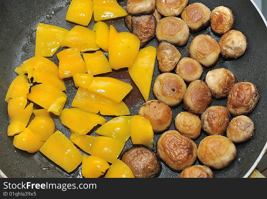 Cooking peppers and mushrooms in a pan