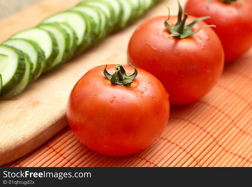 Fresh ripe tomatoes with droplets on bamboo mat