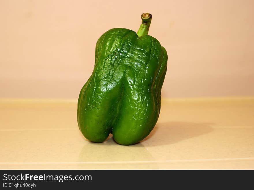 A green capsicum, because of lack of preservation has wrinkled. A green capsicum, because of lack of preservation has wrinkled.