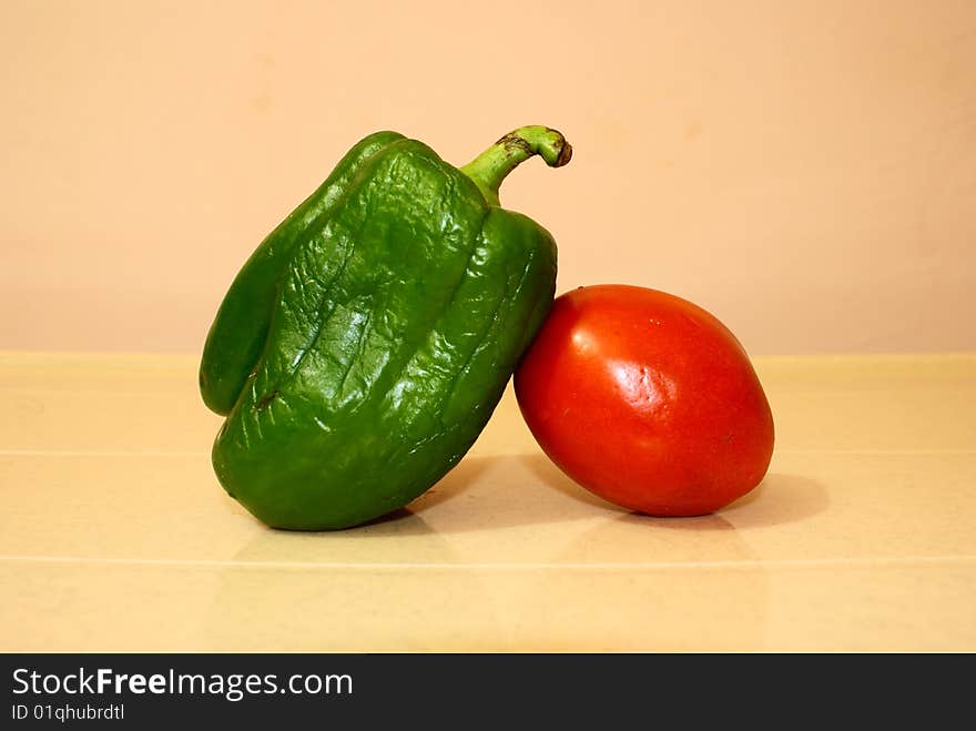 Two colorful vegetables are good friends-green capsicum and red tomato. Two colorful vegetables are good friends-green capsicum and red tomato.