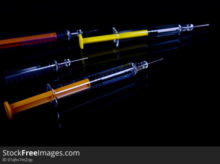 Color syringe on black background