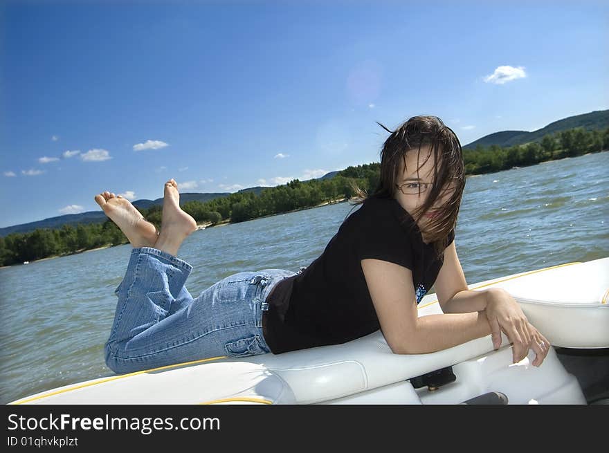 Happy smiling girl relaxing on a motorboat. Happy smiling girl relaxing on a motorboat