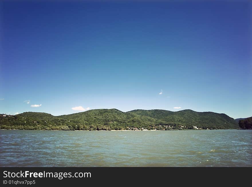 Landscape with river and green hills at the background