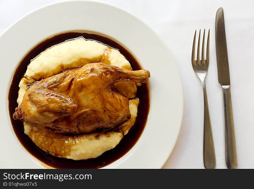 Roasted chicken and mashed potatoes on a dish at restaurant