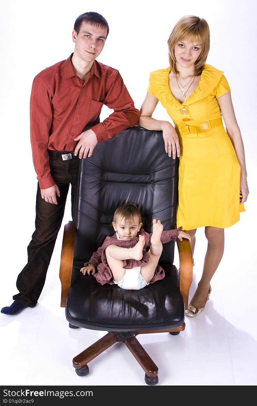 The child sits in an office chair. My mom and dad close by.