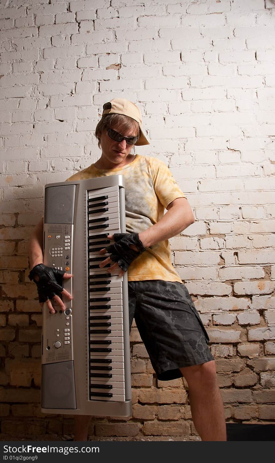 Portrait of musician with synthesizer near brick wall