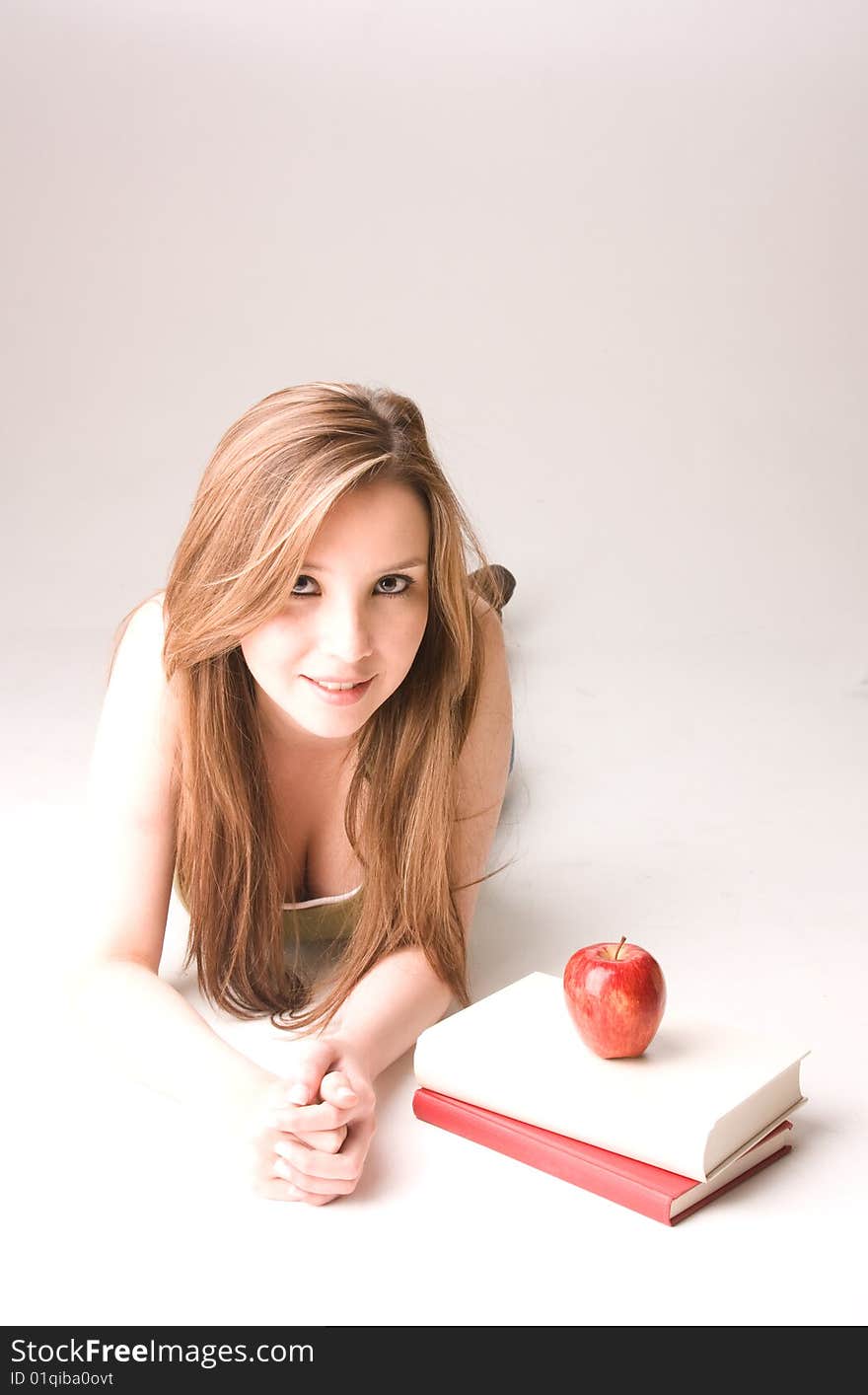 Young and beautiful student with apple and books