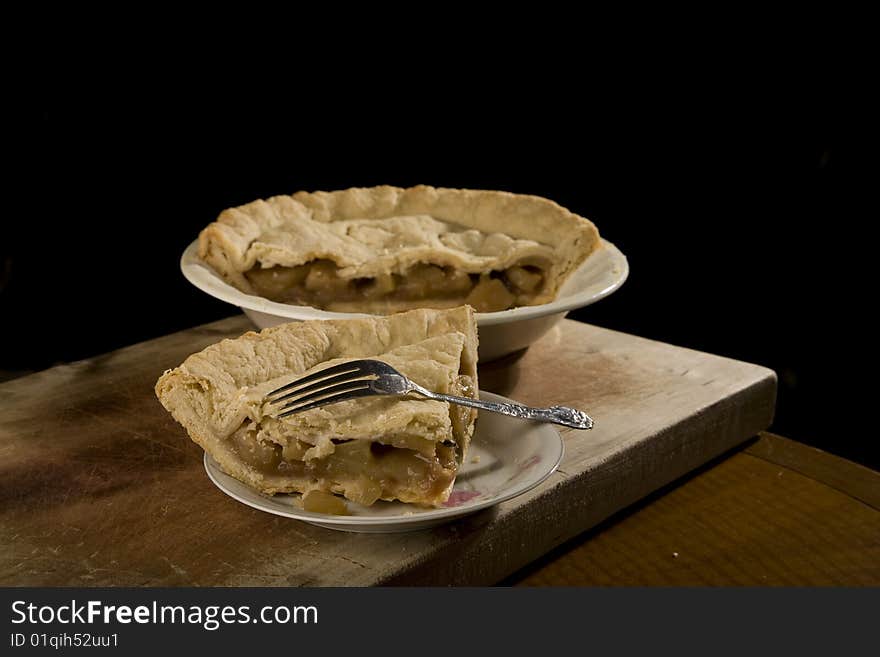 Apple pie with slice of apple pie on plate with fork. Apple pie with slice of apple pie on plate with fork.