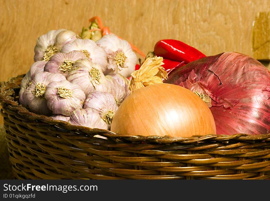 onions and garlic in a wicker basket on a shelf in the storage room. onions and garlic in a wicker basket on a shelf in the storage room