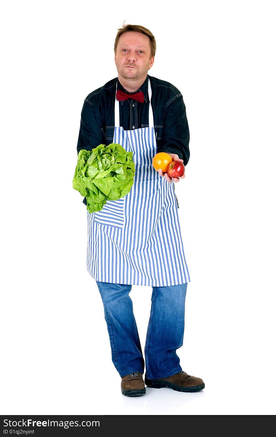 Happy cook showing some fresh vegetables and fruits on white background, reflective surface