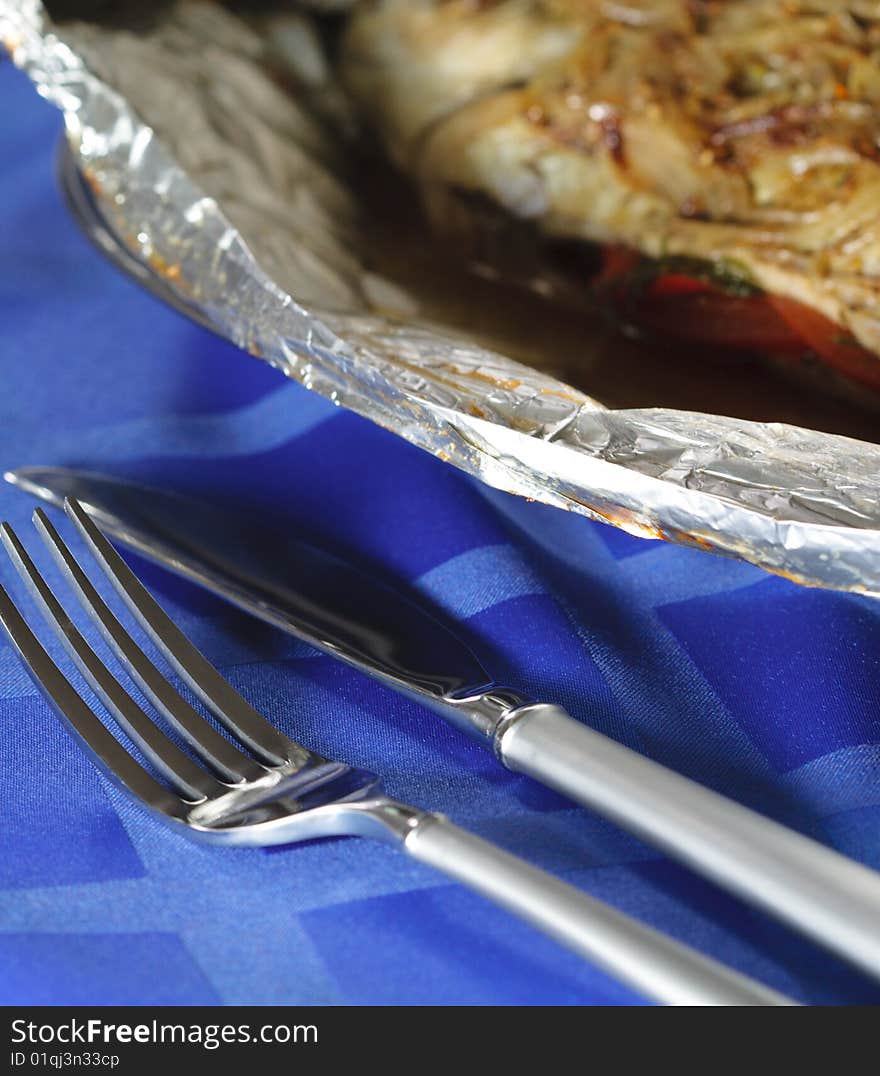 Fork and Knife and Hot Fish Dishes in Foil