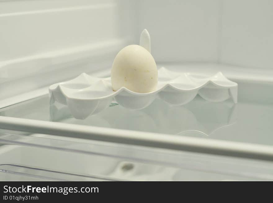 Photo of one egg in a cell in a refrigerator. Photo of one egg in a cell in a refrigerator