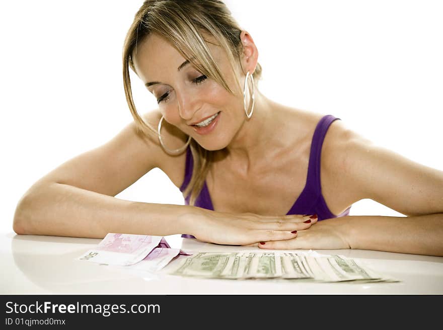 Woman leaning on a table looking at some cash. Woman leaning on a table looking at some cash