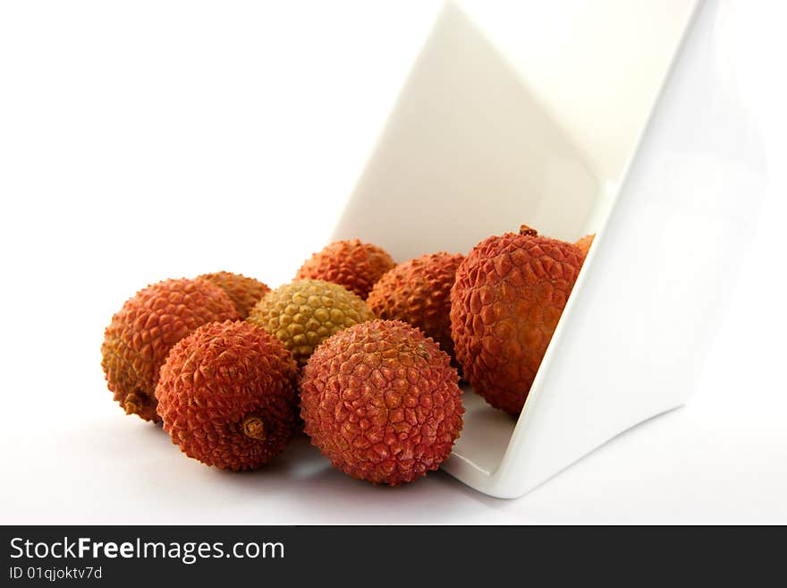 Lychee spilling out a dish with clipping on a white background. Lychee spilling out a dish with clipping on a white background