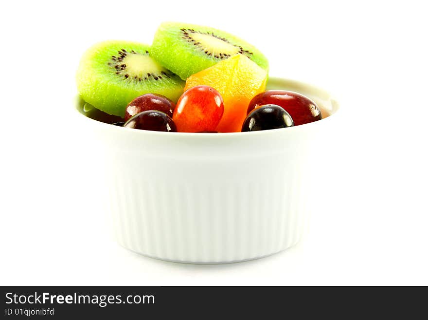 Pot of fruit including kiwi, melon and grapes with clipping path on a white background. Pot of fruit including kiwi, melon and grapes with clipping path on a white background