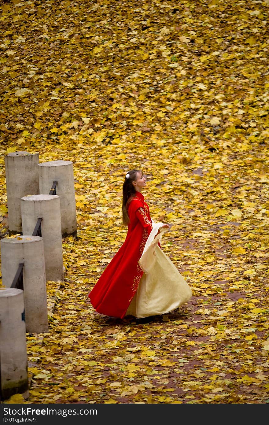 Lady in medieval red dress in the autumn forest. Lady in medieval red dress in the autumn forest