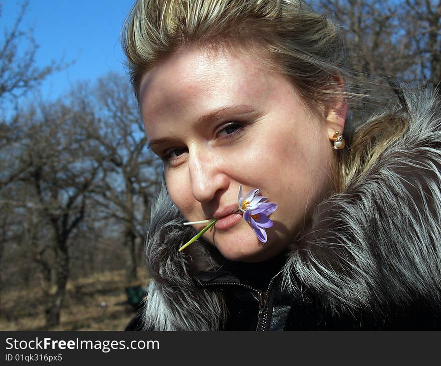 Woman in spring forest, lips holds snowdrops. Woman in spring forest, lips holds snowdrops