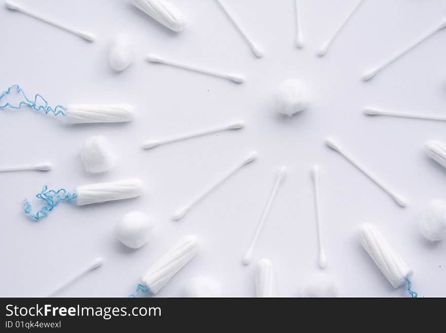 A pattern of arranged female sanitary items, including tampons, cotton wool and cotton buds. The pattern is in a circular design, similar to a sun. A pattern of arranged female sanitary items, including tampons, cotton wool and cotton buds. The pattern is in a circular design, similar to a sun.