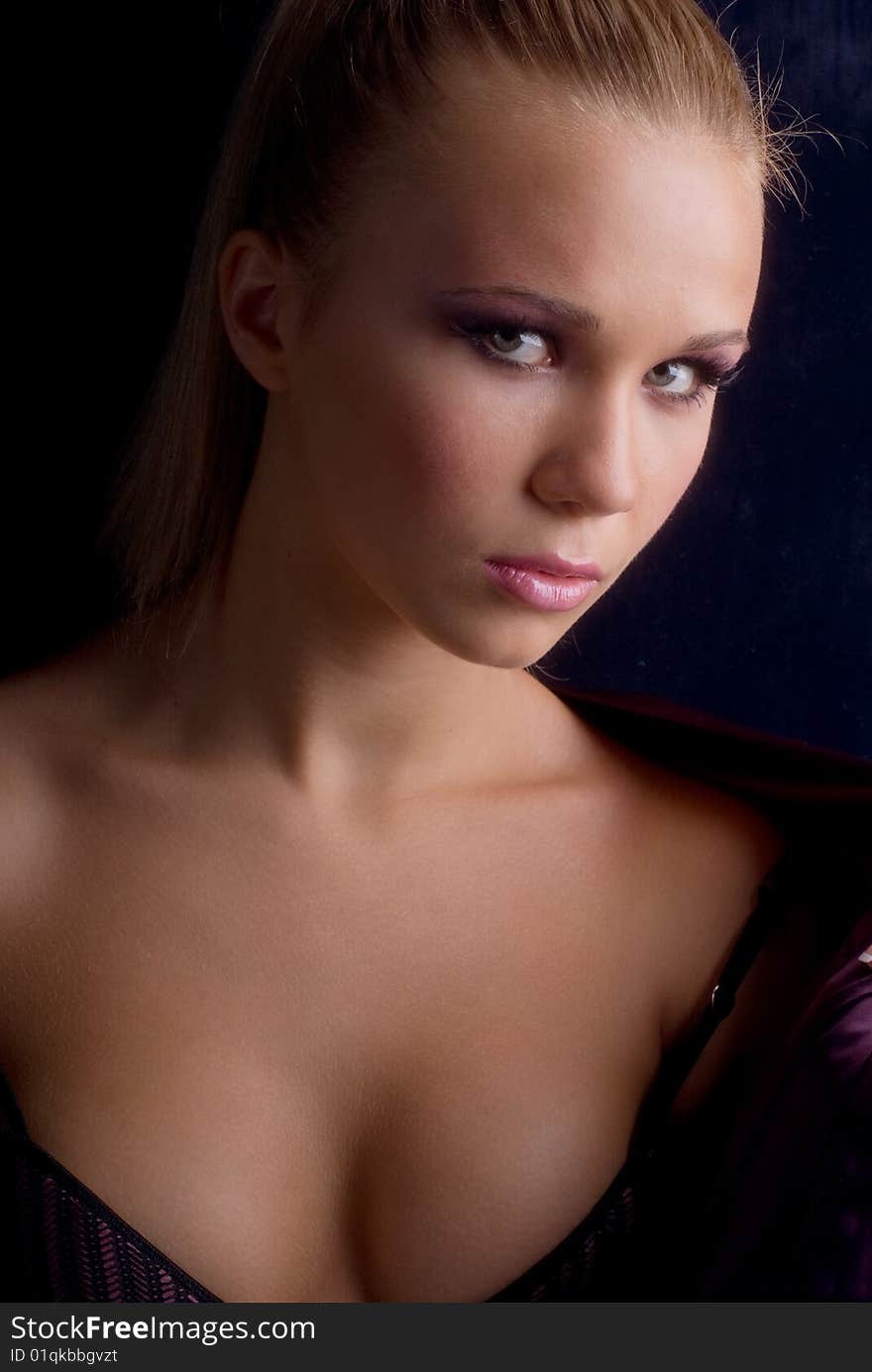 Portrait of a young beautiful girl in their underwear and lilac jacket on a black background. Portrait of a young beautiful girl in their underwear and lilac jacket on a black background