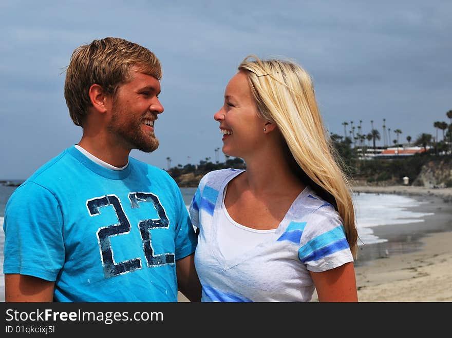 A couple on the beach smiling happily at each other. A couple on the beach smiling happily at each other.