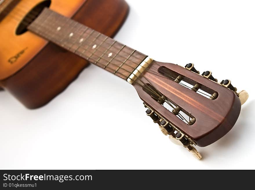 The headstock and fretboard of a wooden acoustic guitar. The headstock and fretboard of a wooden acoustic guitar.