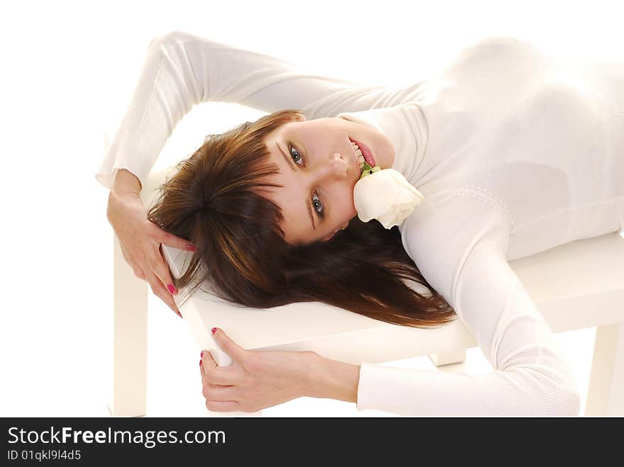 Young woman in white dress whith white roses in yer hands laying on table isolated on white. Young woman in white dress whith white roses in yer hands laying on table isolated on white