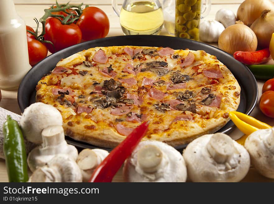 A couple of delicious pizzas, with raw tomatoes, green peppers and mushrooms. A couple of delicious pizzas, with raw tomatoes, green peppers and mushrooms