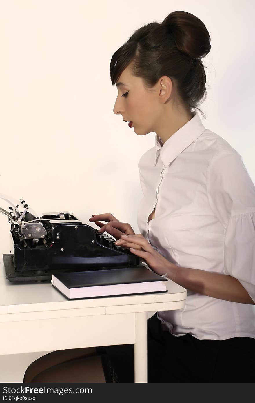 Secretary working with vintage typewriter, shot in studio. Secretary working with vintage typewriter, shot in studio