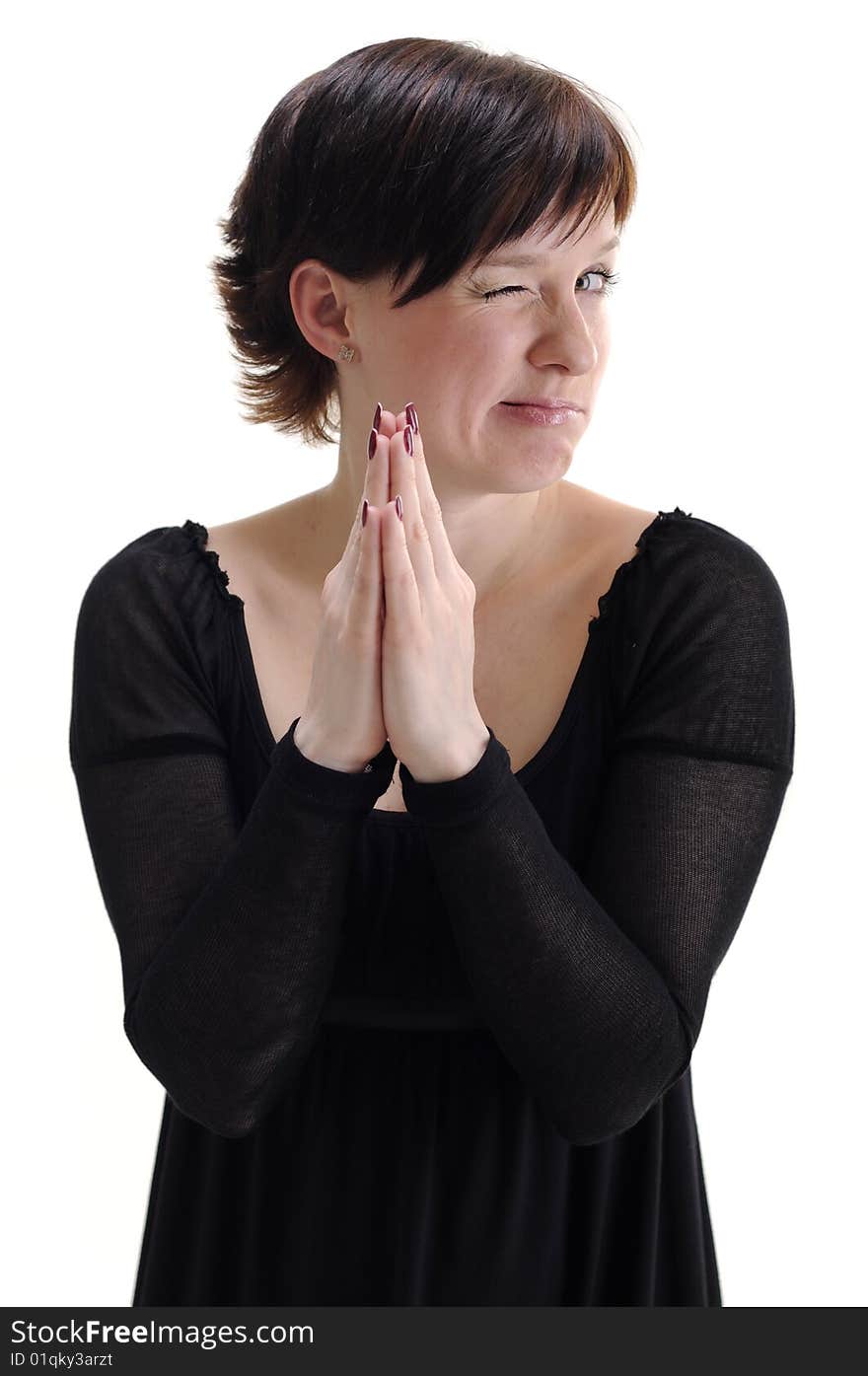 Young woman in black dress praying and blinking isolated on white. Young woman in black dress praying and blinking isolated on white