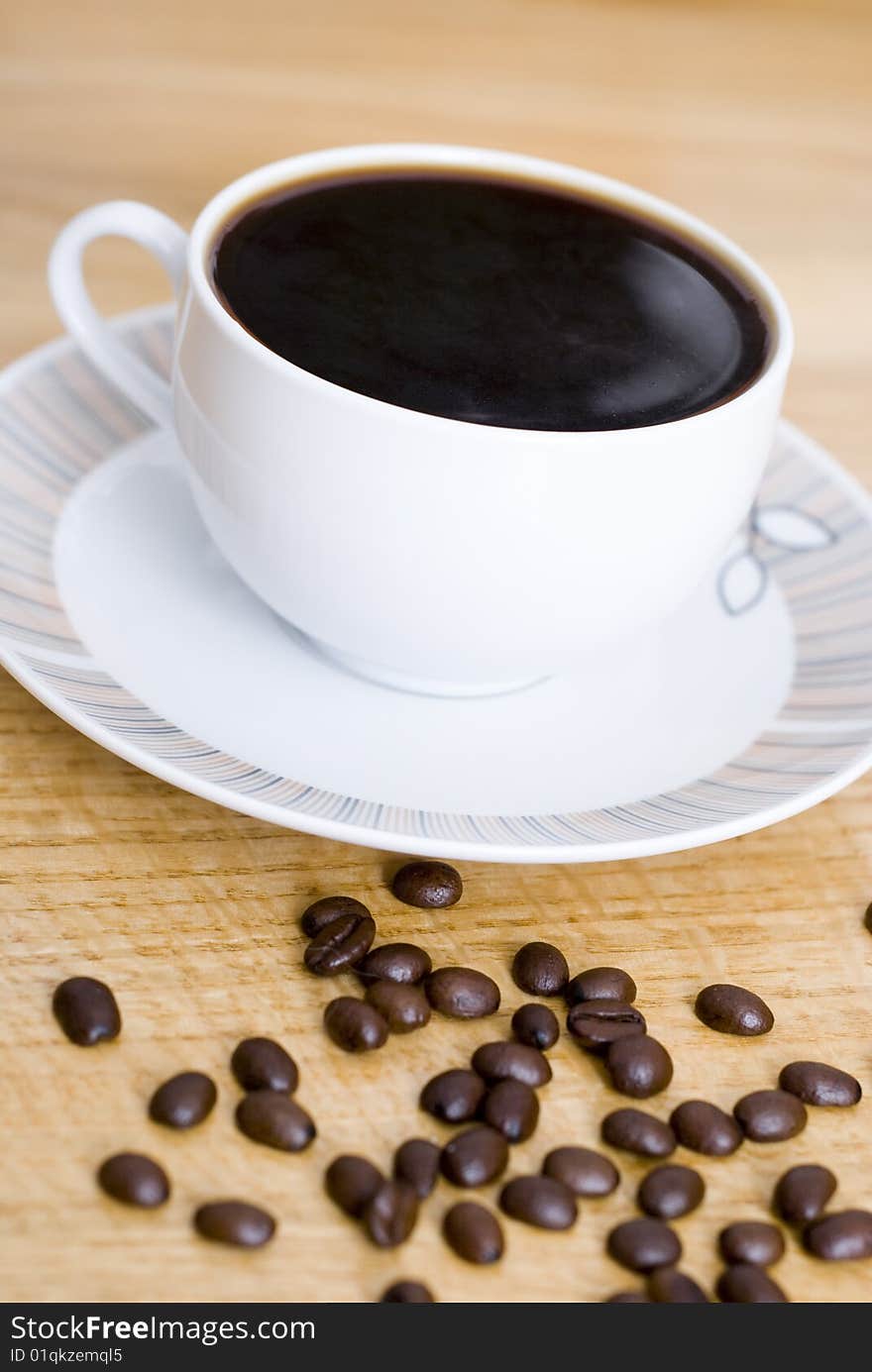 A delicious cup of coffee and some coffee beans. A delicious cup of coffee and some coffee beans