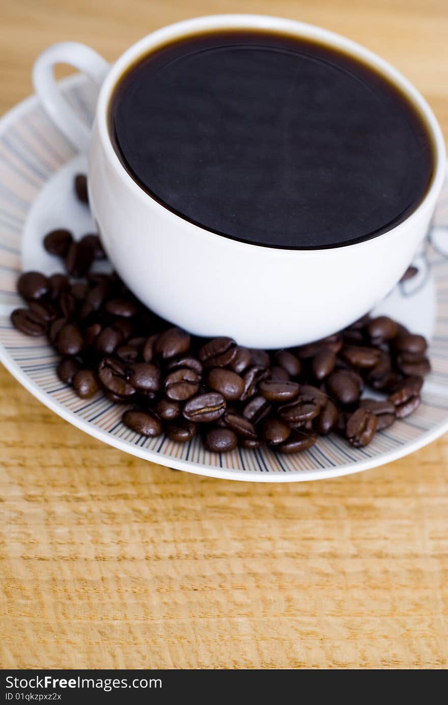 A delicious cup of coffee and some coffee beans. A delicious cup of coffee and some coffee beans