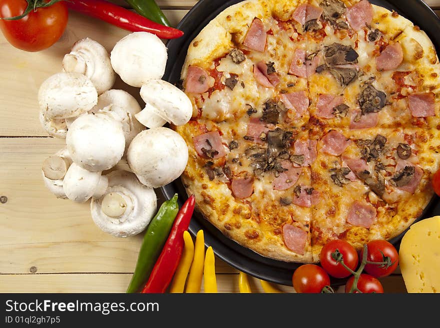 A couple of delicious pizzas, with raw tomatoes, green peppers and mushrooms. A couple of delicious pizzas, with raw tomatoes, green peppers and mushrooms