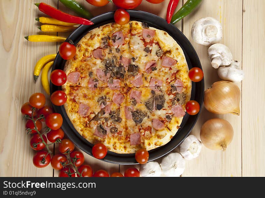 A couple of delicious pizzas, with raw tomatoes, green peppers and mushrooms. A couple of delicious pizzas, with raw tomatoes, green peppers and mushrooms