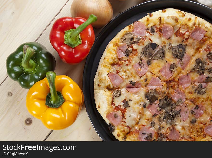 A couple of delicious pizzas, with raw tomatoes, green peppers and mushrooms. A couple of delicious pizzas, with raw tomatoes, green peppers and mushrooms