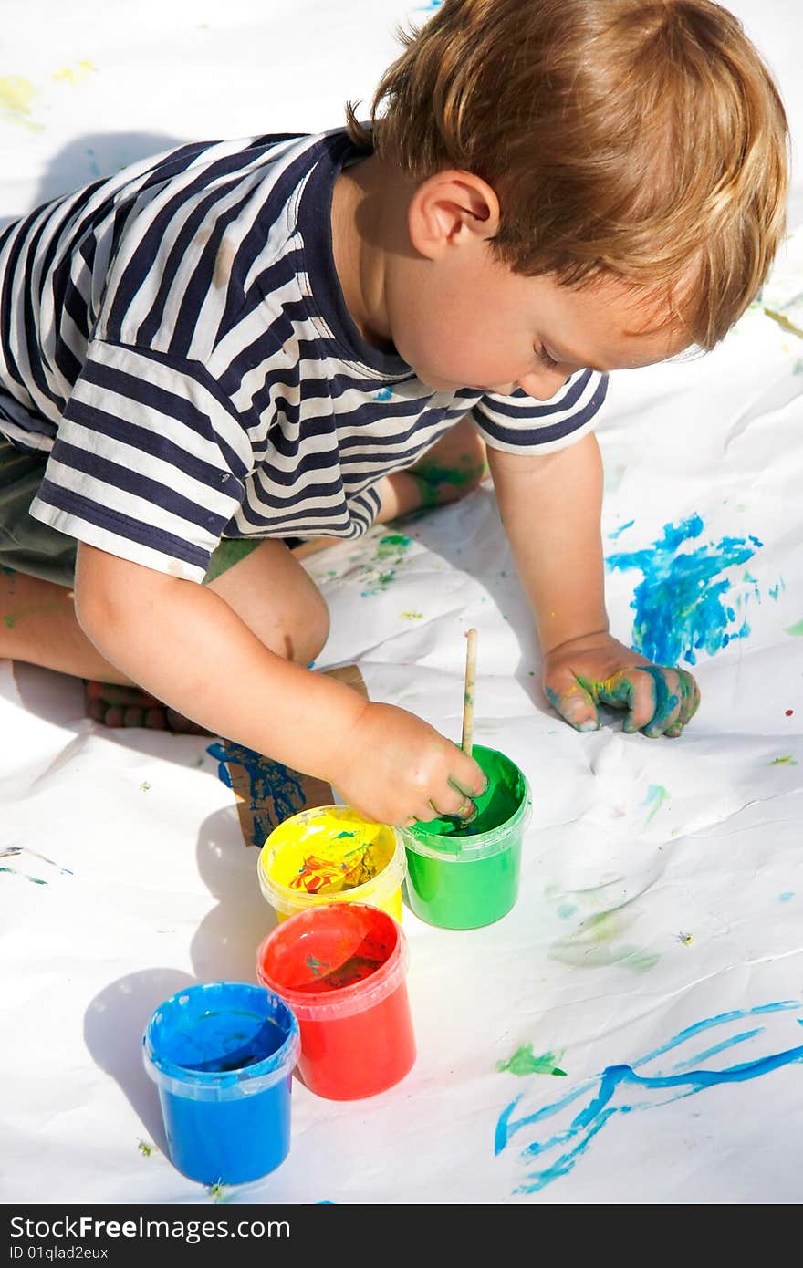 Young boy painting over white