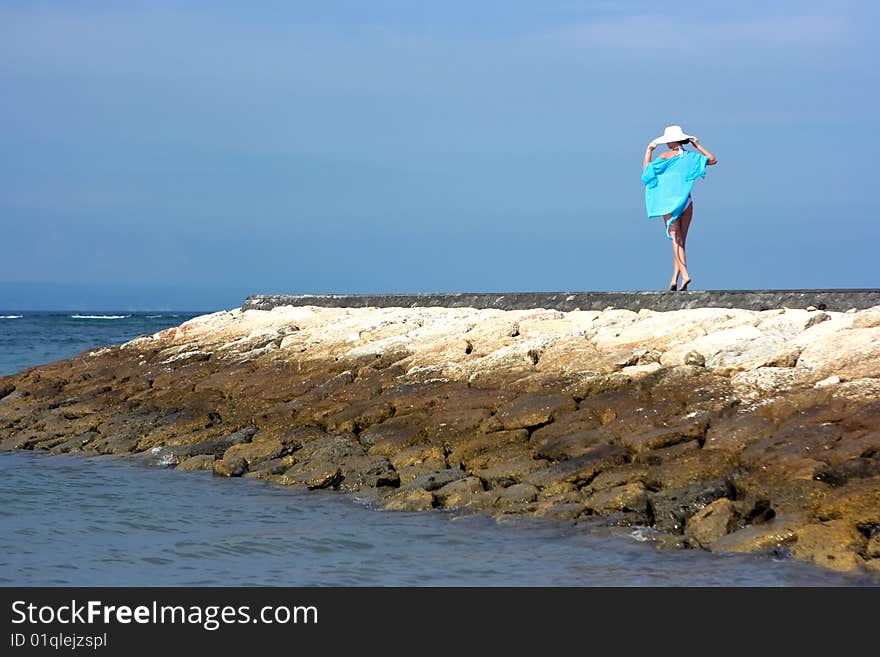 Brunette girl in white hat standing alone on the pier. Brunette girl in white hat standing alone on the pier