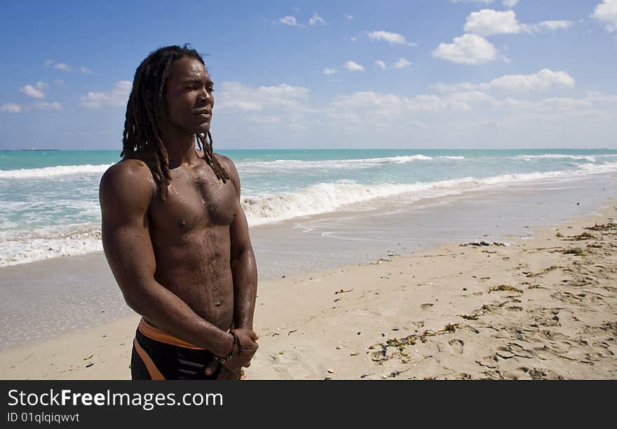 Black man thinking on the beach back in the blue sea over blue sky. Black man thinking on the beach back in the blue sea over blue sky