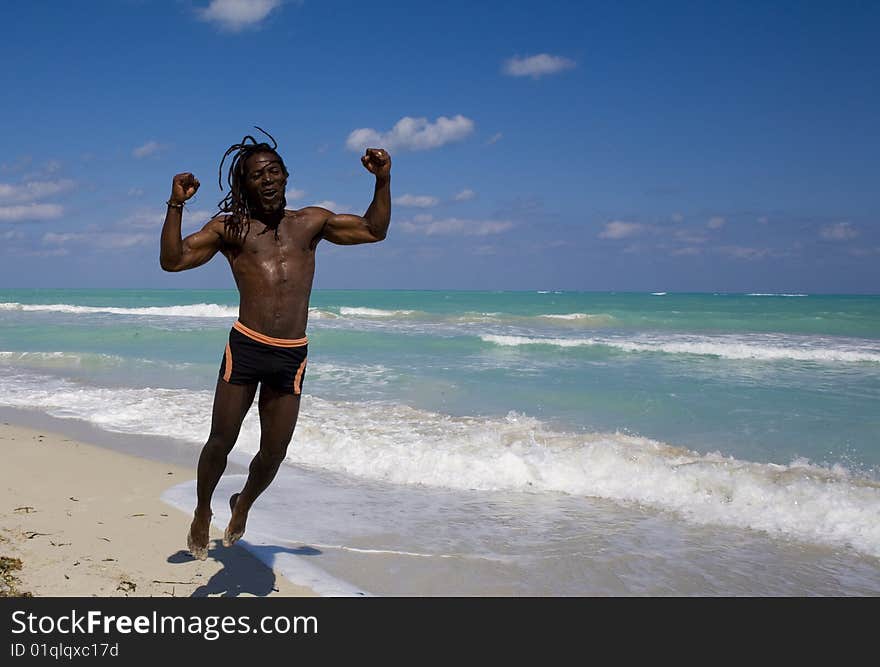 Black man jumping on the beach over blue sea and blue sky. Black man jumping on the beach over blue sea and blue sky