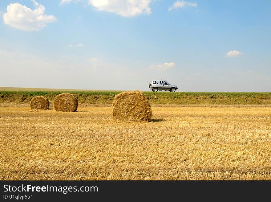 Field with three rolls of straw