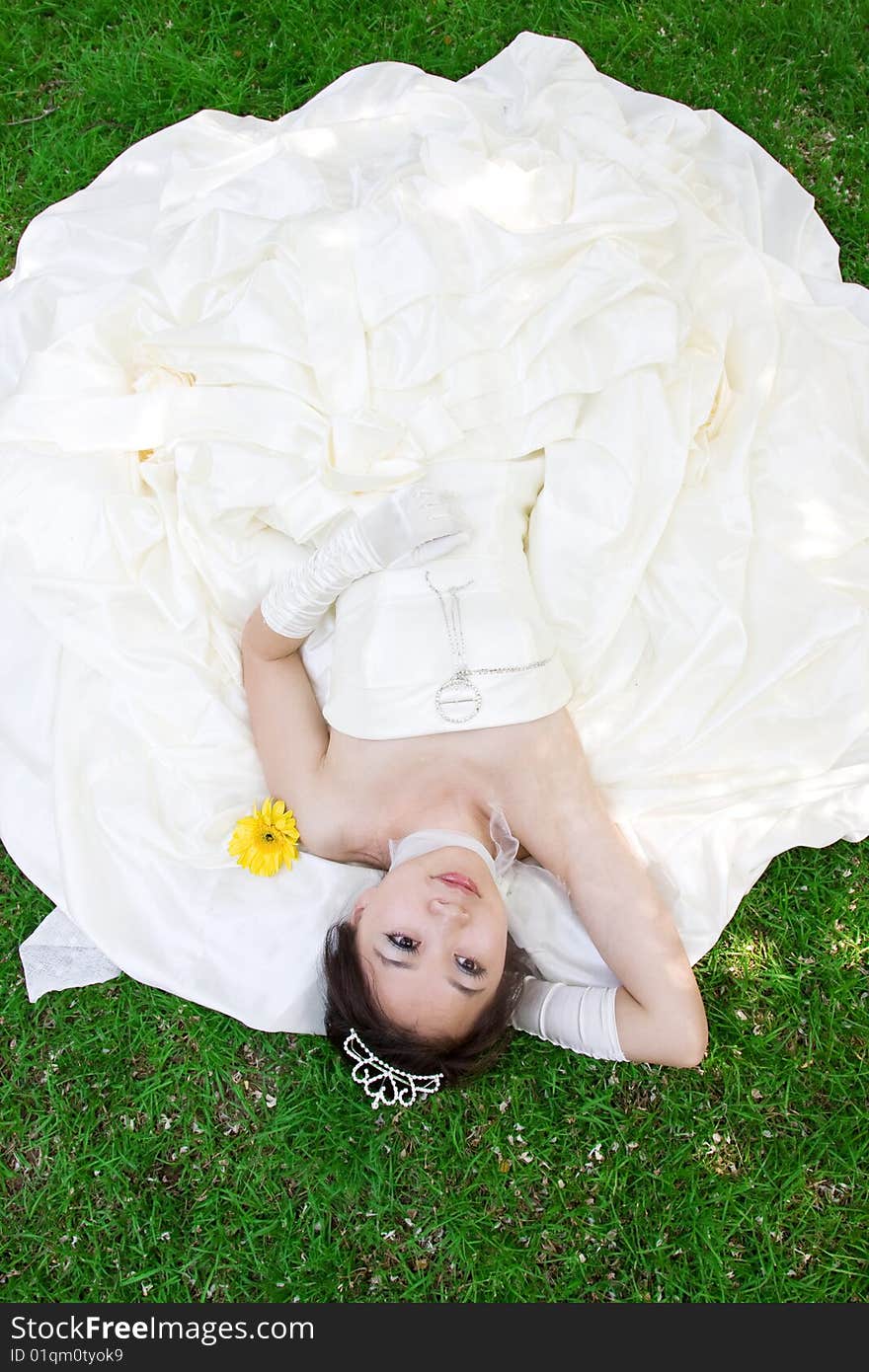 Pretty bride lying on the grass