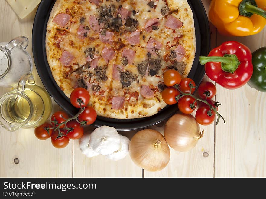 A couple of delicious pizzas, with raw tomatoes, green peppers and mushrooms. A couple of delicious pizzas, with raw tomatoes, green peppers and mushrooms