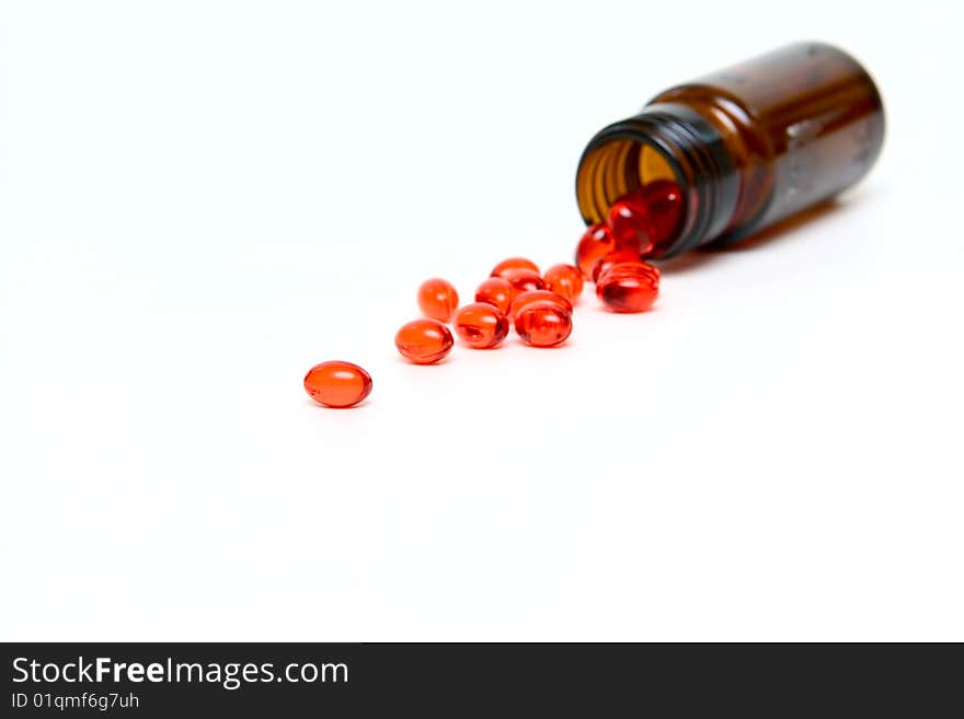 Glass Small bottle with medicine capsules isolated on white