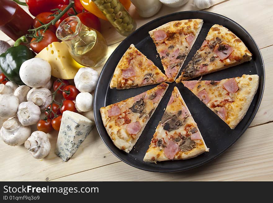 A couple of delicious pizzas, with raw tomatoes, green peppers and mushrooms. A couple of delicious pizzas, with raw tomatoes, green peppers and mushrooms